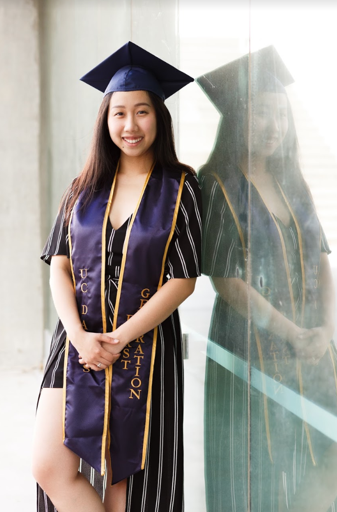 Kathy Pham stands next to a glass door wearing her first-generation stole. 