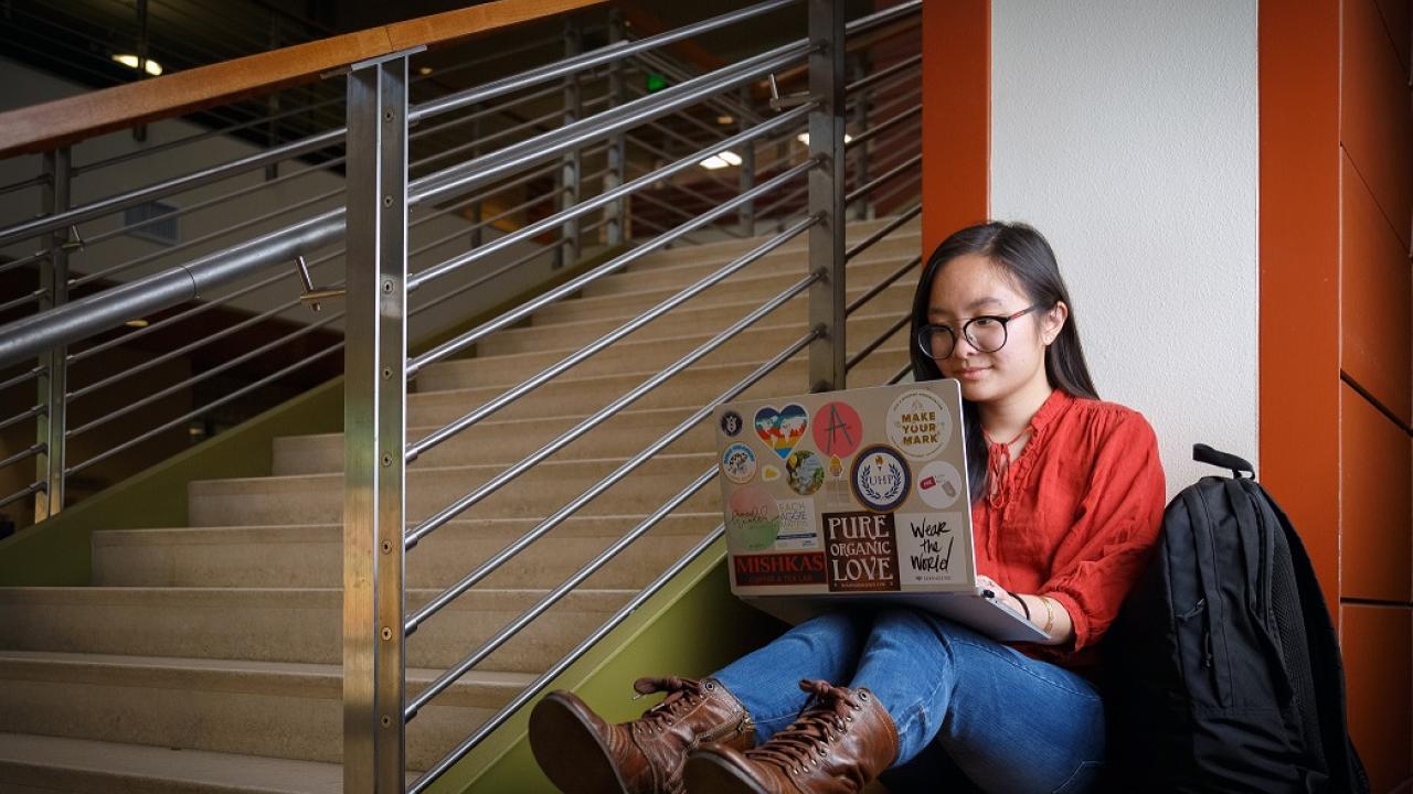 Jennifer La sitting in the SCC while using her laptop. 