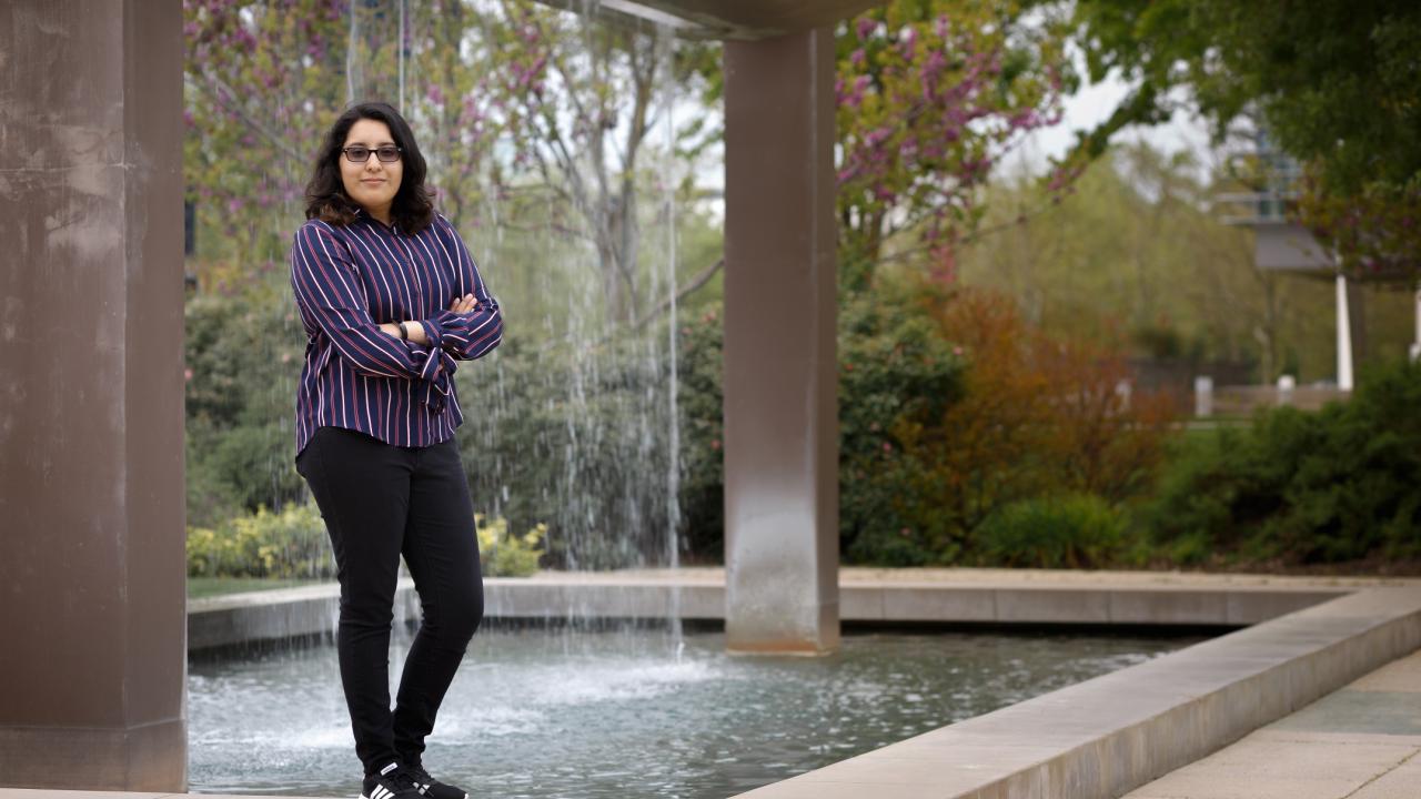 First-generation college student, Joyce Zamorano standing in front of the UC Davis Welcome Center fountain.