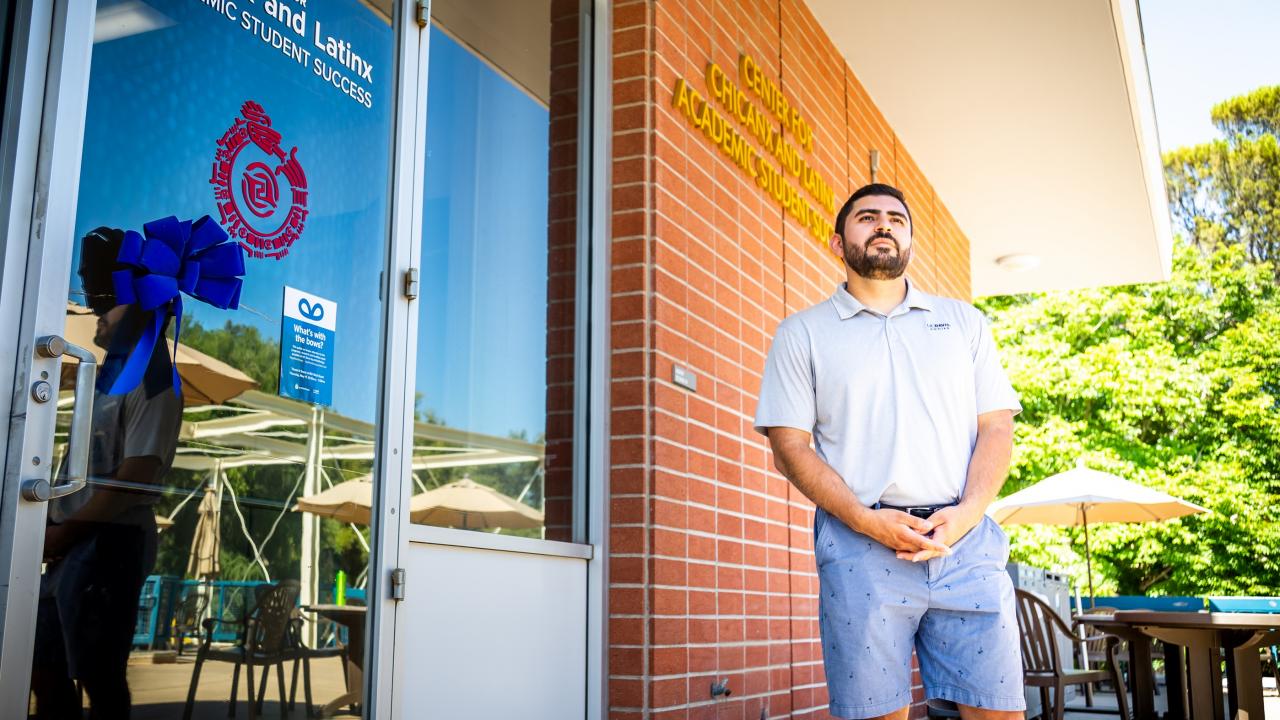 First Generation College Transfer Student, Jose Macias, stands in front of the Center for Chicanx and Latinx Academic Student Success. 
