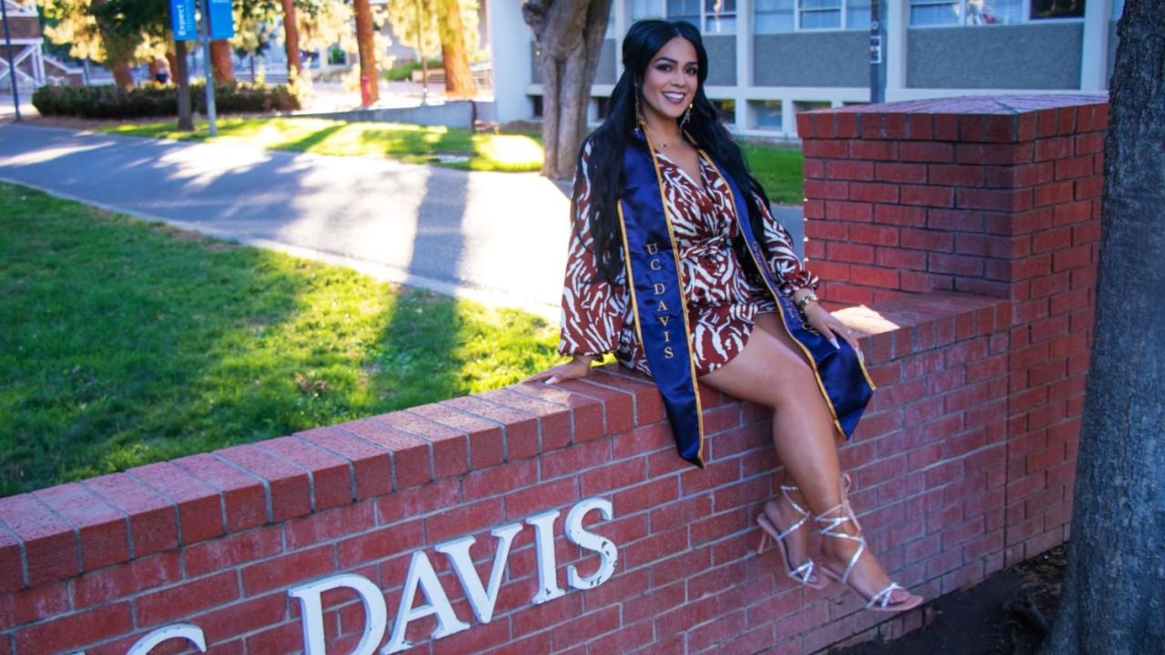 Johni Rose Zamorano sitting on brick sign