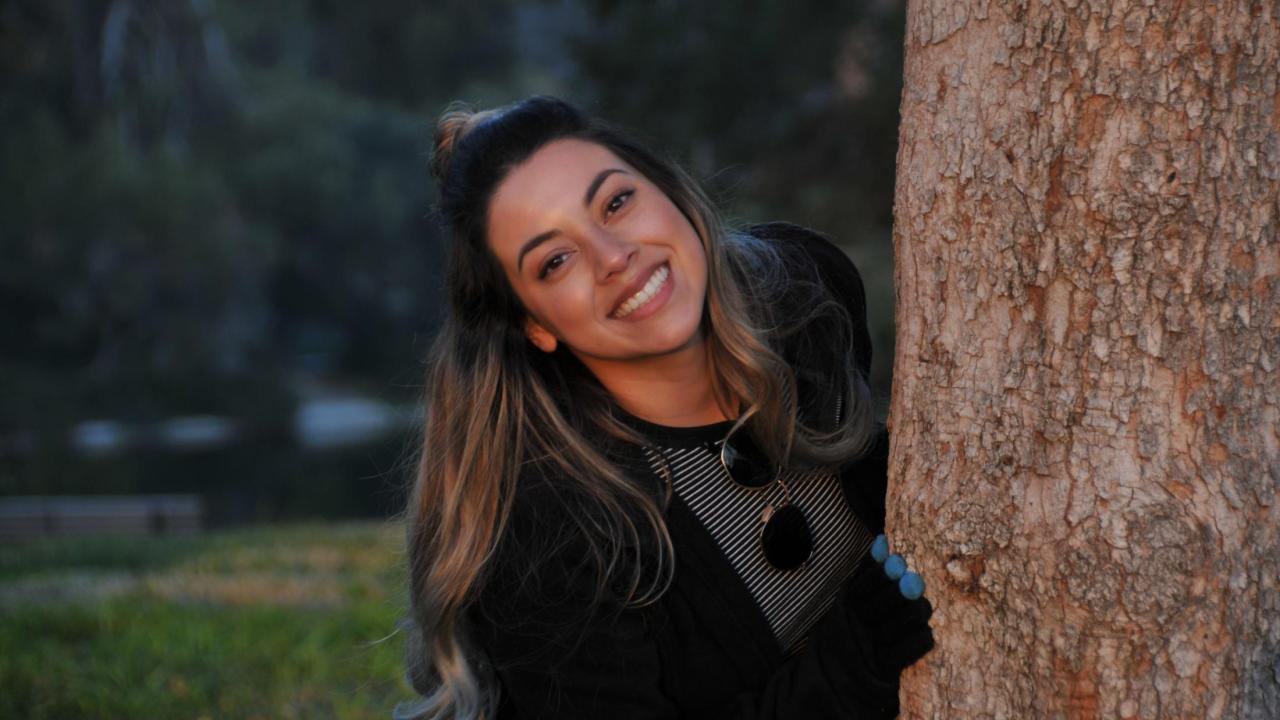 Evelyn Alvarez behind a tree