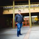First Generation College Student Dave Ivan Cruz stands in front of the Student Community Center (SCC).